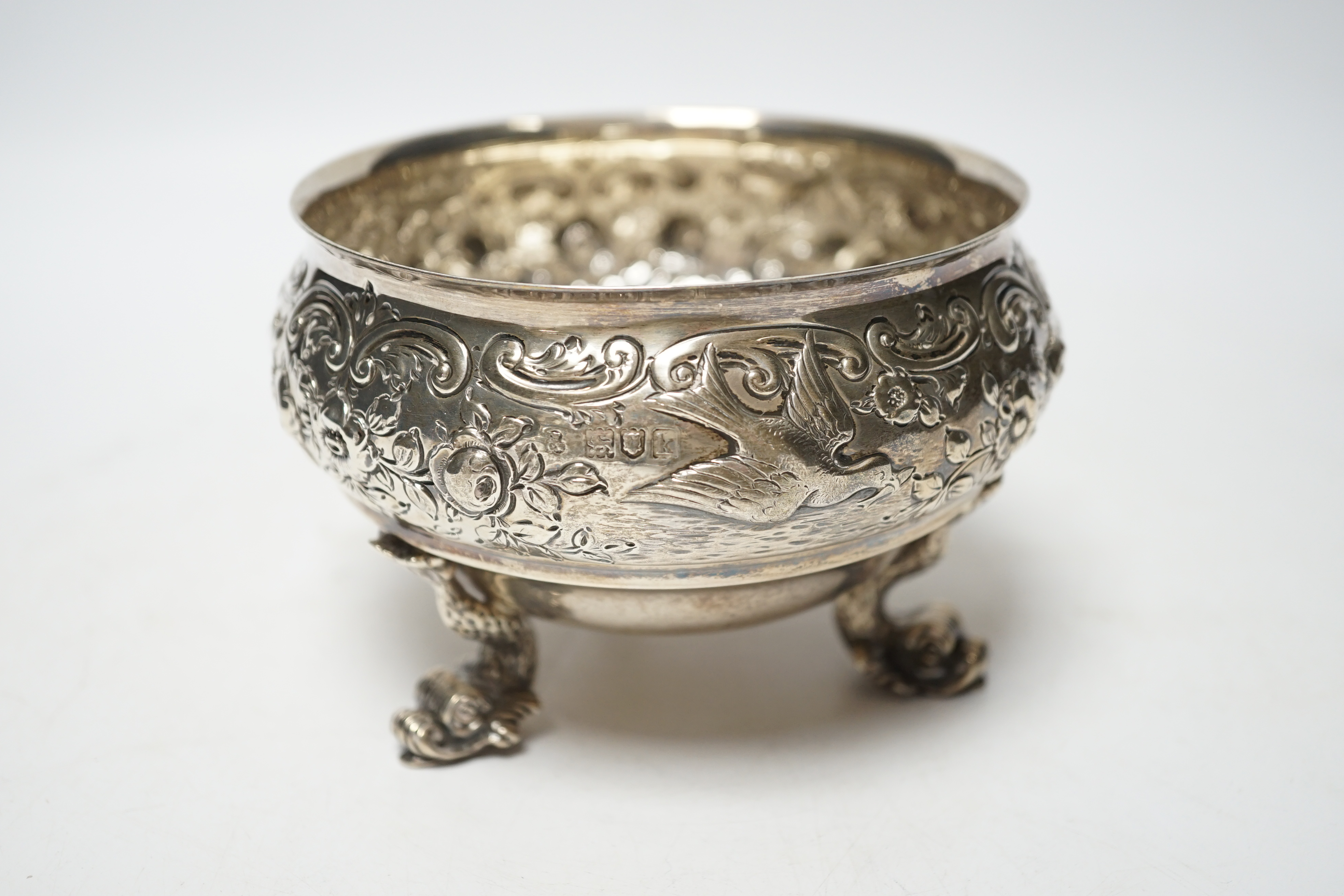 An Edwardian embossed silver bowl, on three dolphin supports, Wakely & Wheeler, London, 1905, diameter 11.6cm, 11.4oz.
